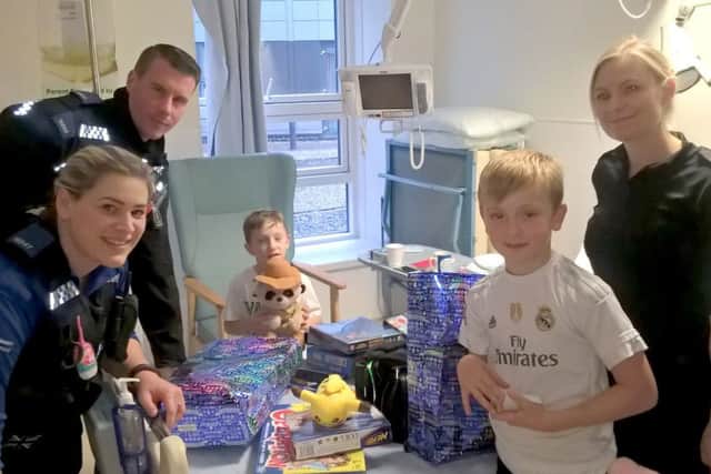 Jude Allen, seated, and his older brother Oscar meet the PCSOs at QA Hospital Picture: Hampshire Constabulary