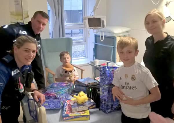 Jude Allen, seated, and his older brother Oscar meet the PCSOs at QA Hospital Picture: Hampshire Constabulary