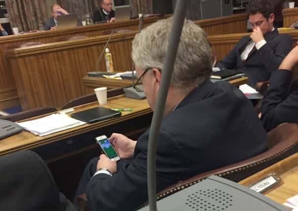Gerald Vernon-Jackson on his phone playing Solitaire during the latest full council debate in Portsmouth.