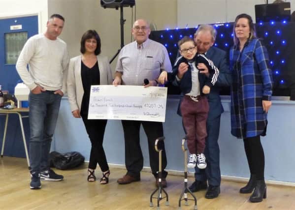 Bill Edwards presenting Aiden Farrell's cheque following the pigeon auction fundraiser with his parent, Gevun and Sara, auctioneer Tony Cowan and his wife Maria