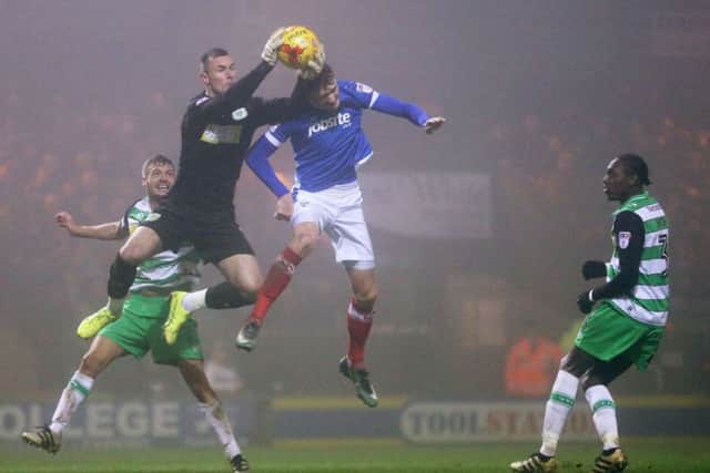 Michael Smith competes for a high ball with Yeovil Town keeper Artur Krysiak. Picture: Joe Pepler