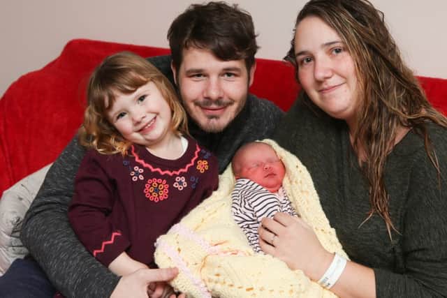 Baby Mabel, who was born at 12.30am on New Year's Day, with her parents Sadie Foster and Joseph Saunders and her sister Nancy, three Picture: Habibur Rahman (170003-55)