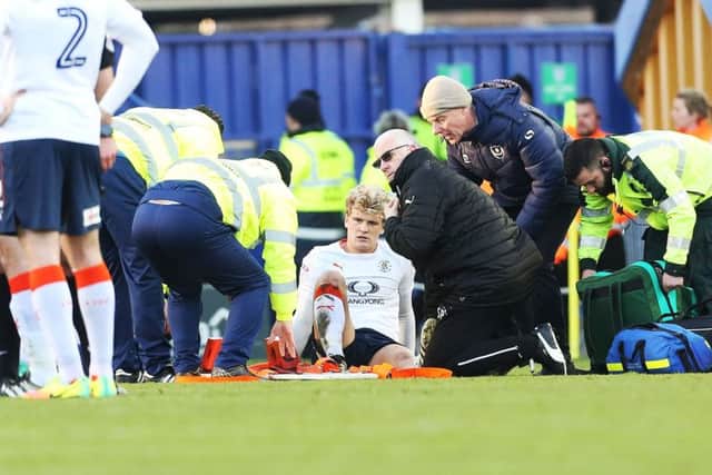 Cameron McGeehan receives treatment on the pitch following a challenge with Pompey's Michael Doyle Picture: Joe Pepler