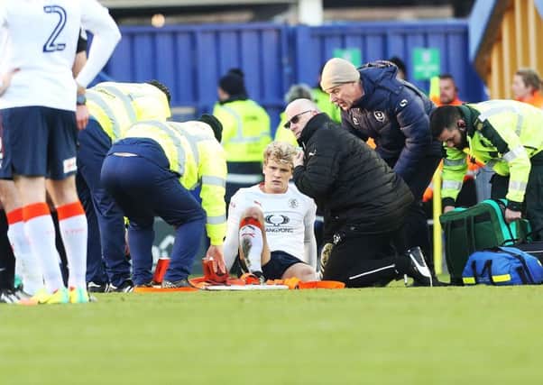 Cameron McGeehan receives treatment on the pitch following a challenge with Pompey's Michael Doyle Picture: Joe Pepler