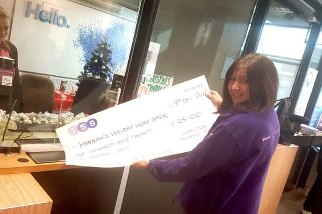 Pam Marshall is handed a cheque for Â£125 for Hannahs Holiday Home