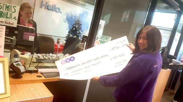 Pam Marshall is handed a cheque for Â£125 for Hannahs Holiday Home