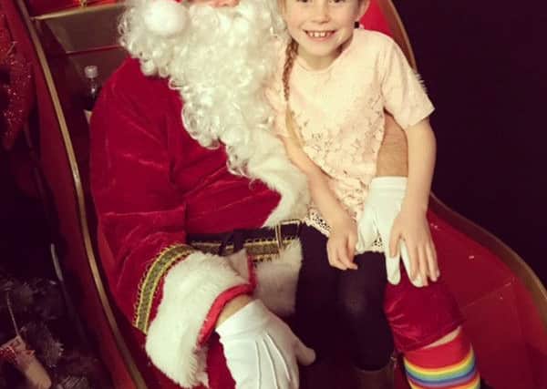 Santa with a youngster on one of his stops on the 15-day Gosport Rotary Club sleigh tour