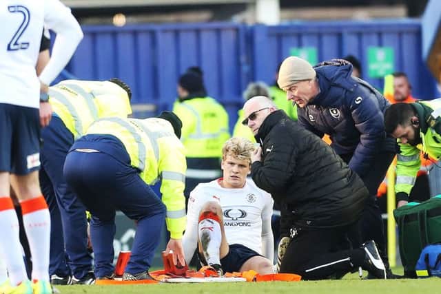 Luton's Cameron McGeehan is stretchered off on Monday. Picture: Joe Pepler