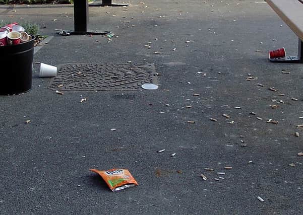A picture by David Lee of some of the cigarette butts and other rubbish scattered outside the QA