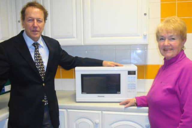 Titchfield Abbey WI past president Rosemary Mitchell recently presents the microwave oven for community use to Titchfield Parish Room chairman Richard Ashton