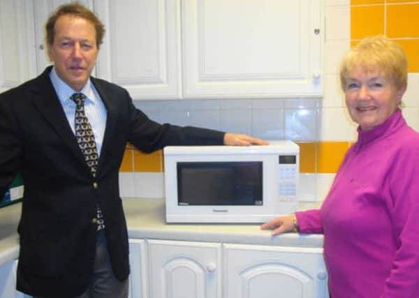 Titchfield Abbey WI past president Rosemary Mitchell recently presents the microwave oven for community use to Titchfield Parish Room chairman Richard Ashton