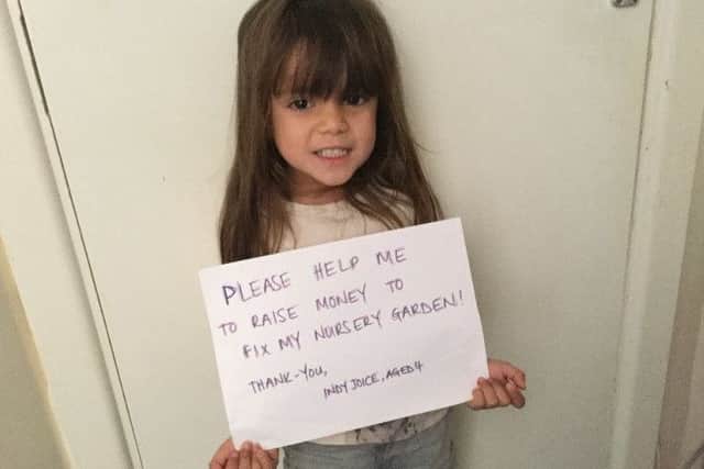 Indira-Kiki Joice holding a sign up to help YMCA Nursery in Gosport raise funds after a vandal attack