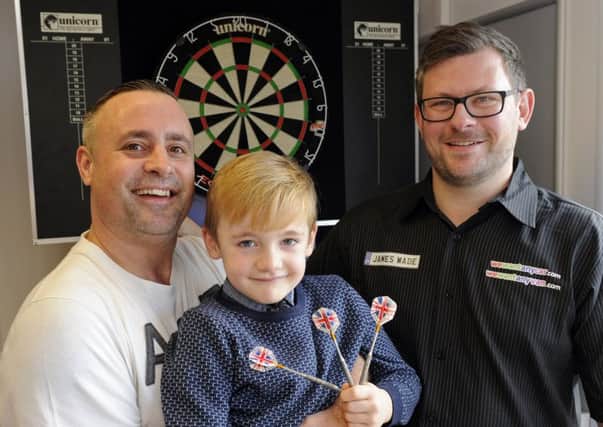 Steve Grant, 40, from Waterlooville with his son Lewie Grant, six, and darts player James Wade.

Picture: www.waa.co.uk