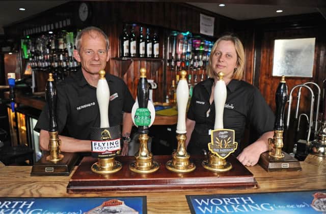 Martin and Diane Munns behind the bar of their pub, The Fareham. The couple recently donated 27 DVD players to the childrens ward of Queen Alexandra Hospital, Cosham