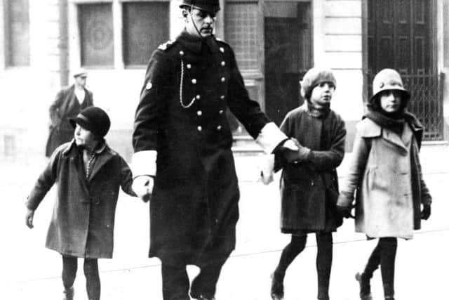 HELPING HAND Pictured crossing Commercial Road, Portsmouth, with three children is PC Bill Kempster