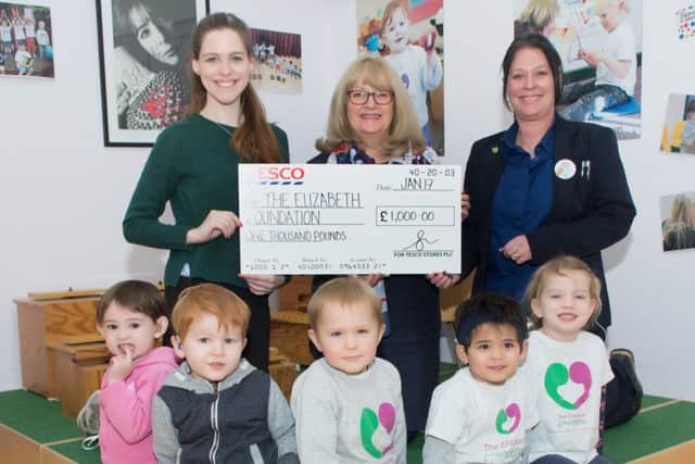 Mandi Myers, community champion at the Tesco Extra store in Portsmouth's Clement Attlee Way presenting Fiona Heath, Elizabeth Foundation fundraising manager, with the £1,000