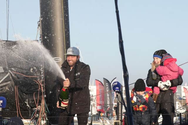 Gosport's Alex Thomson is watched by his wife Kate, son Oscar and daughter Georgia, as he celebrates with champagne after finishing second in the Vendee Globe race Picture: Yui Mok/PA Wire