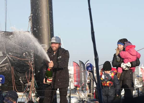 Gosport's Alex Thomson is watched by his wife Kate, son Oscar and daughter Georgia, as he celebrates with champagne after finishing second in the Vendee Globe race Picture: Yui Mok/PA Wire