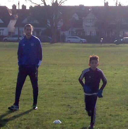 Christian Burgess watches training for the under-12 side