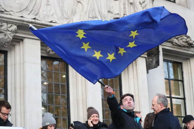 A man waves a flag outside the Supreme Court in London where Britain's most senior judges will rule if Theresa May has the power to trigger the formal process for the UK's exit from the European Union. PRESS ASSOCIATION Photo. Picture date: Tuesday January 24, 2017. Ministers are braced for the Supreme Court to decide that Parliament must be given a vote on starting the divorce proceedings. See PA story POLITICS Brexit. Photo credit should read: Jonathan Brady/PA Wire PPP-170124-104207001