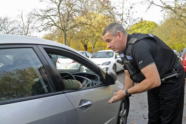 File photo of roads policing officer PC Mark Fruin talking to a man caught using his phone