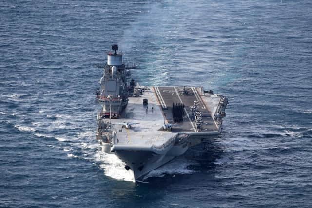 Sailors gather on the deck of Russian aircraft carrier Admiral Kuznetsov.   PHOTO: L(Phot) Dave Jenkins