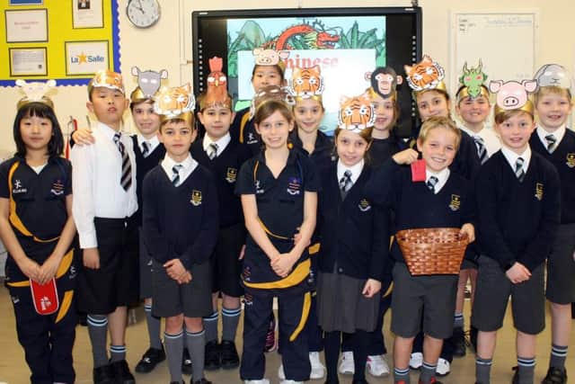jpns-27-01-17-005 St Johns College CNYChinese New Year workshopsYear 4 students with Miss Tong Liu learning how to write  Chinese Zodiac animals in Cantonese. (Left to Right: Clara Beardall, age 9, Bryony Michael age 9, Miss Tong Liu, Ziqing (Cherry) Zhang, age 9 and  Zhiyu (Nancy) Lan age 9.