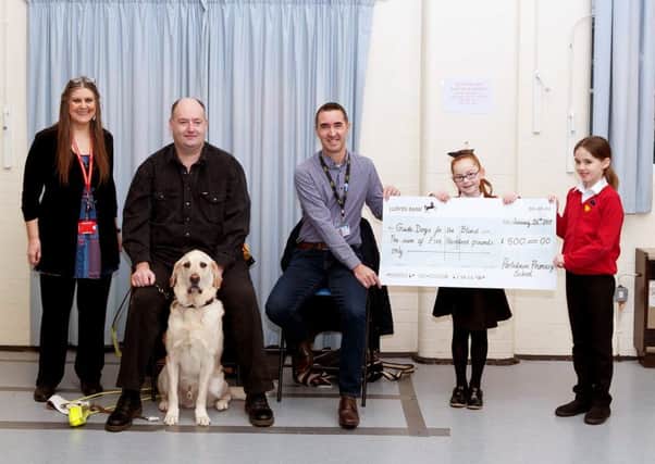 Portsdown Primary School raise record amount for Guide Dogs for the Blind
caption Left to right:
Daphne Wright, Deputy head teacher, Ian Morris, Volunteer speaker for Guide dogs with Gunner,  Leigh Thresher, community fund raiser for Hampshire Guide dogs, Connie a year 3 pupil and Matilda a year 3 pupil.
Picture: Daphne Wright