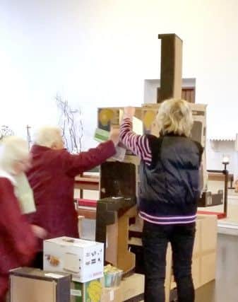 People build a wall with boxes during the service