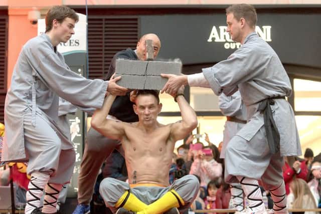 Matt Bindon has two bricks broken over his head in a performance by the UK Shaolin Temple in Gunwharf Quays  Picture: Keith Woodland