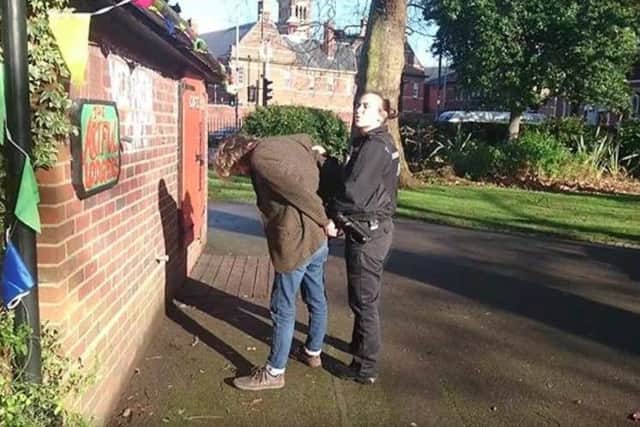 A still from the video showing the Arts Lodge's Mark Lewis handcuffed by police