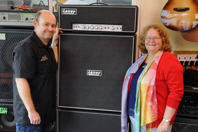 Steve Wright, left, of the Guitar Centre in Highlands Road, Southsea with Tina Hinks, 66, and her late husband David's Laney guitar amp  Picture: Malcolm Wells (170206-6710)