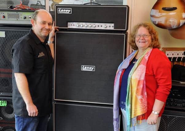 Steve Wright, left, of the Guitar Centre in Highlands Road, Southsea with Tina Hinks, 66, and her late husband David's Laney guitar amp  
Picture: Malcolm Wells (170206-6710)