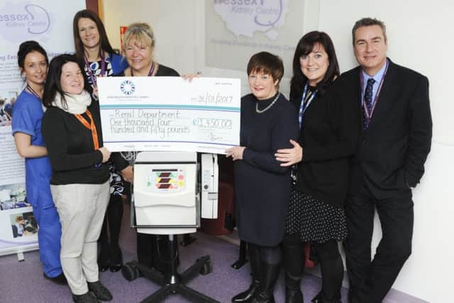 Jackie Hill, wife of Graham Hill, handing over a cheque to QA Hospital's renal unit