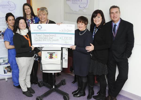 Jackie Hill, wife of Graham Hill, handing over a cheque to QA Hospital's renal unit