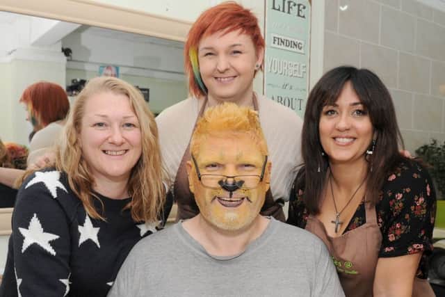 The Rev Sean Blackman at the start of his challenge on November 1, when he was transformed into the charachter of Aslan from The Lion, Witch and the Wardrobe. He's pictured with, from left, face paint artist Rebecca Baird, owner of Diva Hair Studio Amber Roper and hairdresser Kes Suffield Picture: Sarah Standing (161484-9473)