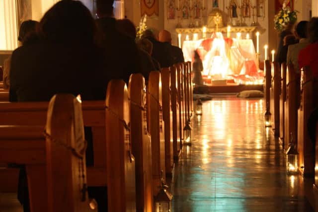 Worshippers in a candlelit service at St Swithuns