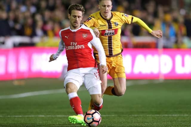 Adam May battles with Arsenal player Nacho Monreal