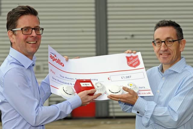 Rob Warburton, left, the community centre manager at The Haven Salvation Army in Lake Road Portsmouth as he receives a cheque from Steve Brown, managing director of Apollo Fire Detectors Picture:  Malcolm Wells (170206-1741)