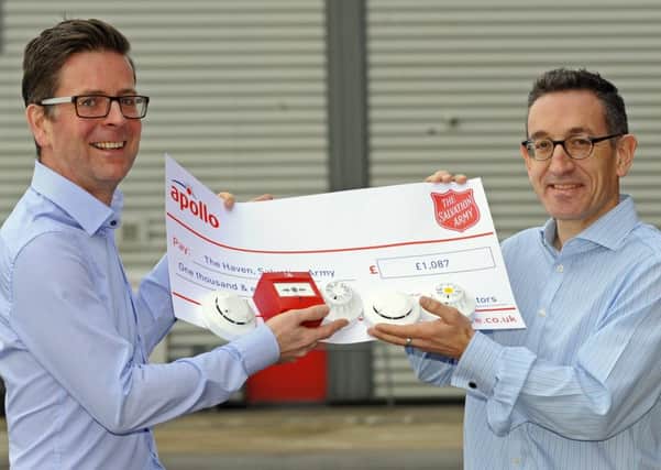 Rob Warburton, left, the community centre manager at The Haven Salvation Army in Lake Road Portsmouth as he receives a cheque from Steve Brown, managing director of Apollo Fire Detectors Picture:  Malcolm Wells (170206-1741)
