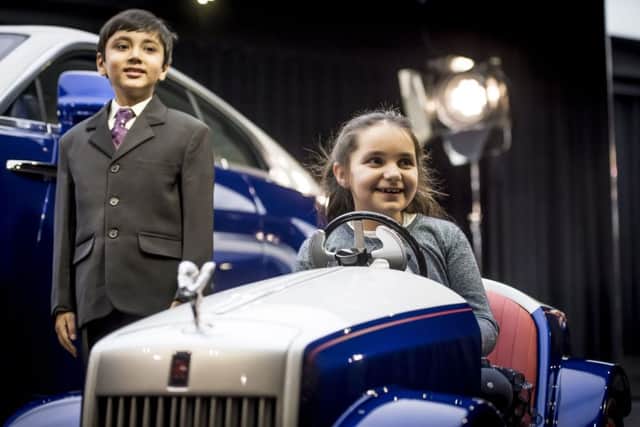 Molly Matthews test driving a Rolls-Royce SRH, which will allow children awaiting surgery at St Richard's Hospital Pediatric Day Surgery Unit. She and Hari Rajyaguru (left) viewed the car being unveiled in style at the company's Goodwood Studio
Picture: James Lipman/PA Wire