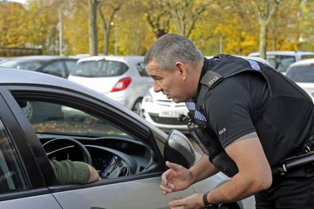 File photo of police handing out a fixed penalty notice to a driver using a mobile phone.