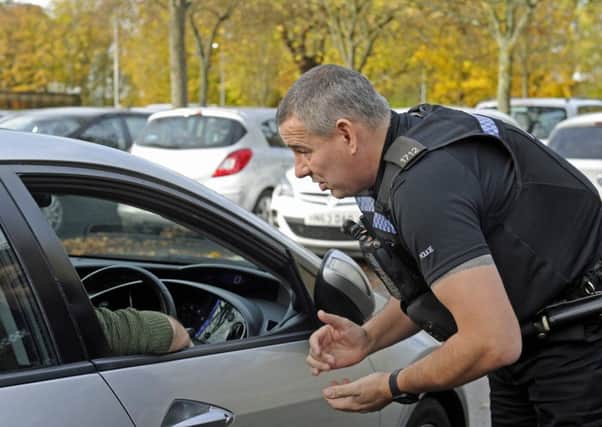 File photo of police handing out a fixed penalty notice to a driver using a mobile phone.