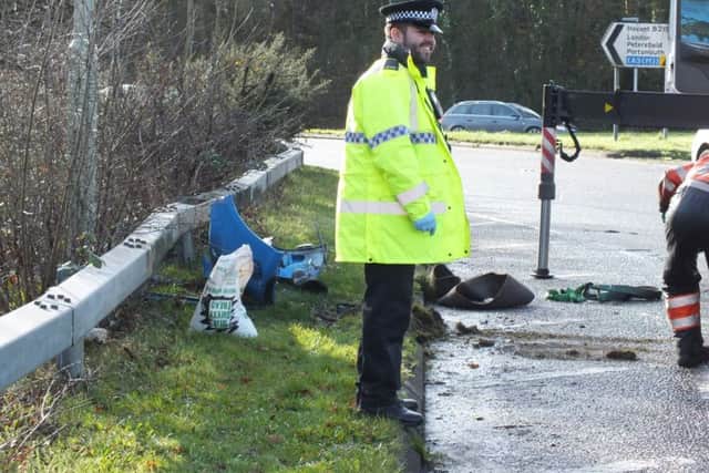 A policeman surveys the roundabout scene. Credit: Malcolm Garbutt