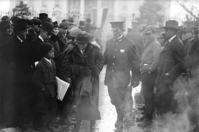 A policeman leads an arrested National Woman's Party protester away from a woman's suffrage bonfire demonstration at the White House in 1918