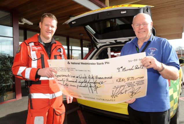 Hampshire and Isle of Wight Air Ambulance paramedic Pat Andrews, left, accepts the cheque from David Frost, chairman of the St Mary's Hospital League of Friends
Picture: Sarah Standing (170284-3725)