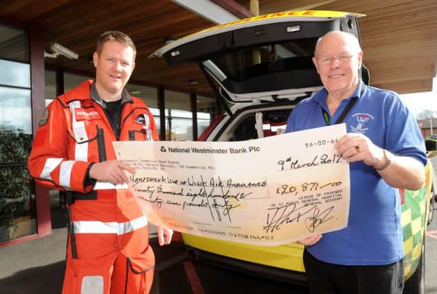 Hampshire and Isle of Wight Air Ambulance paramedic Pat Andrews, left, accepts the cheque from David Frost, chairman of the St Mary's Hospital  League of Friends 

Picture: Sarah Standing (170284-3725)