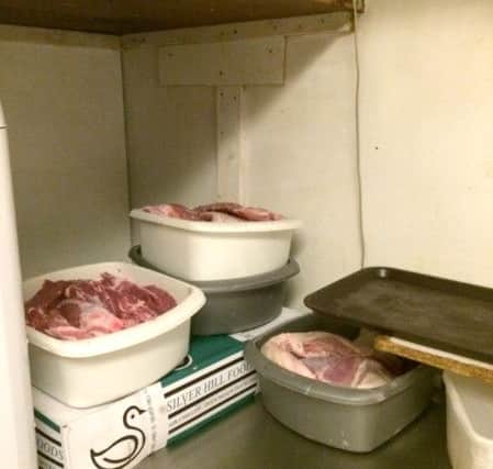 Raw meat in buckets on top of the chest freeezer in the rear store room, at  room temperature