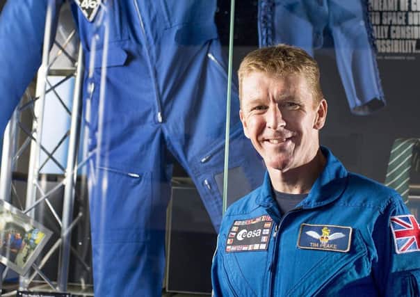 Tim Peake standing next to the suit he wore in space which was donated to the exhibition at The Novium Museum in Chichester, which is up for an award