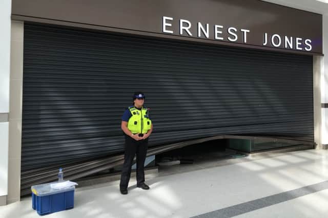 Pictured: A PCSO stands guard outside Ernest Jones where a 'significant' amount of jewellery was stolen. Thieves raided Ernest Jones in Cascades Shopping Centre in Portsmouth on July 26. Picture: Ben Fishwick PPP-160726-142111001